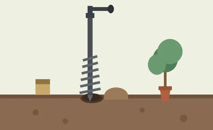 A garden auger with a spiral bit drilling a hole in prepared soil beside a young tree