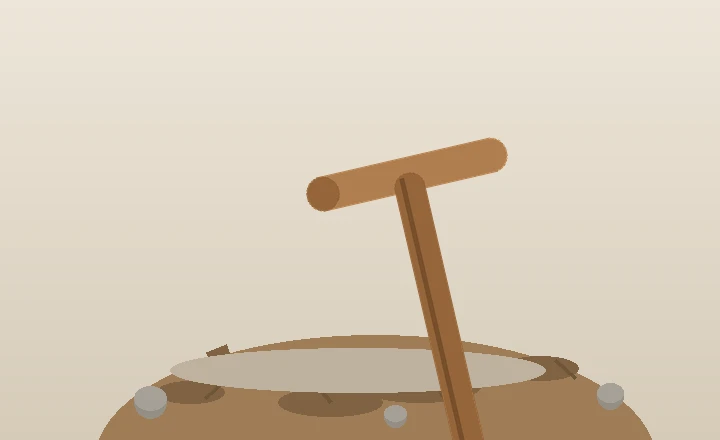 A double-bitted mattock with a pick and broad adze blade resting on broken, stony soil