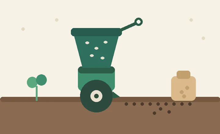 A hand-cranked seed sower with a hopper and wheel beside a fresh row of small seeds in soil